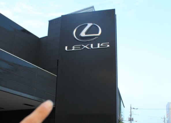 LEXUS,レクサスショールームの外看板を指さす画像